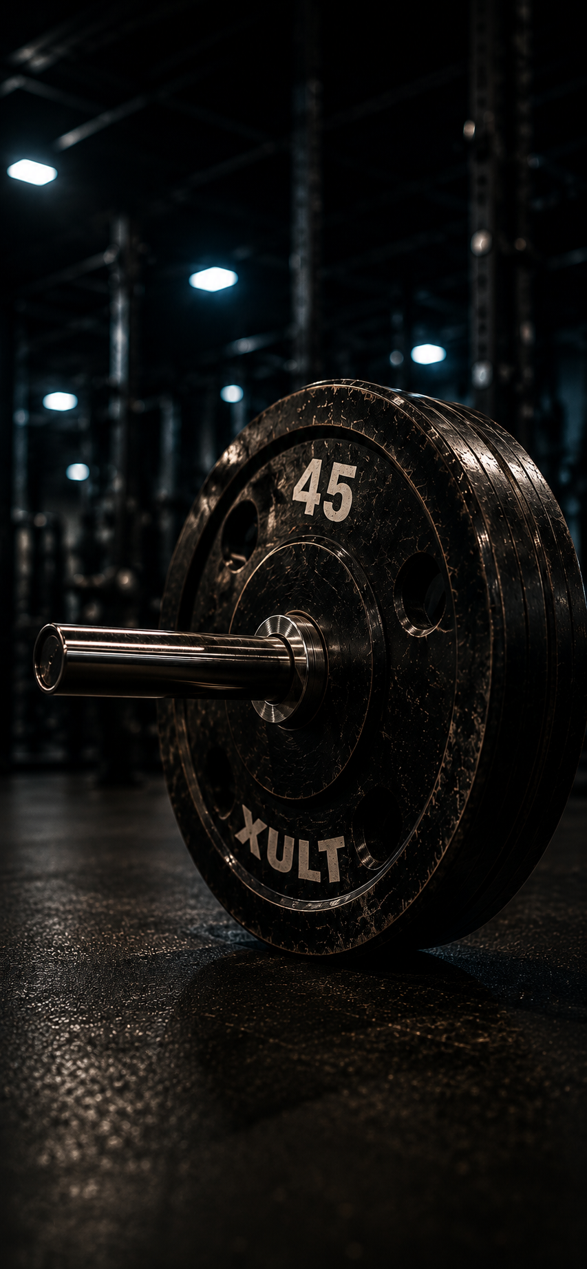 Loaded 45 lb barbell plate resting on a dark gym floor